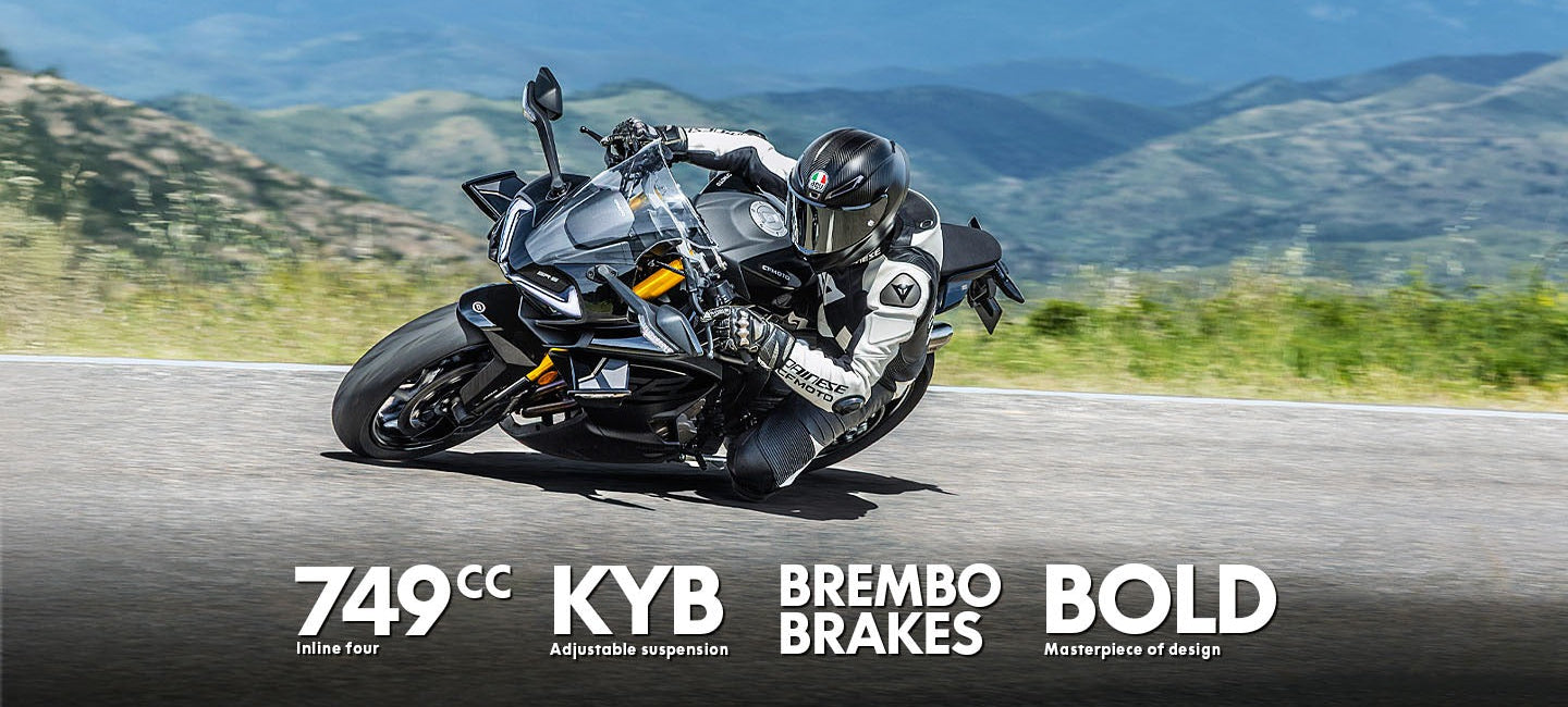 Motorcycle on a road with mountains in the background, featuring KYB, Brembo, and Bold branding.